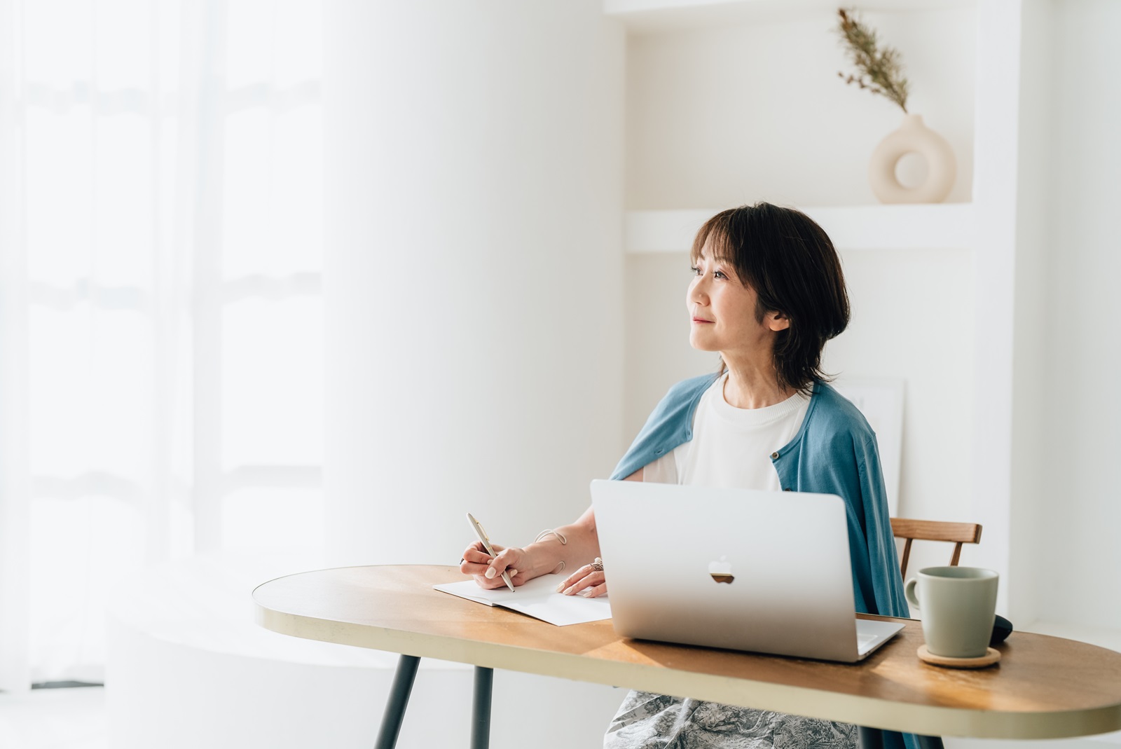 窓辺でノートを書く講師